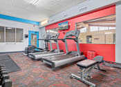 Thumbnail 16 of 24 - A gym with treadmills, weights and exercise equipment.