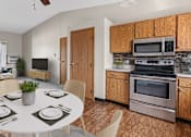 Thumbnail 3 of 11 - a kitchen with stainless steel appliances and a dining table