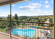 Thumbnail 8 of 11 - a balcony with a view of a swimming pool and trees