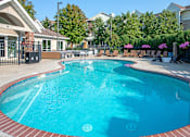 Thumbnail 17 of 20 - a large pool with chairs and a building in the background
