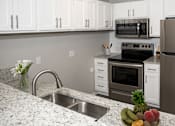Thumbnail 3 of 20 - a kitchen with stainless steel appliances and granite counter tops