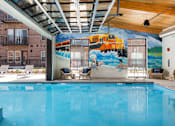 Thumbnail 37 of 40 - Indoor pool area with seating and mural