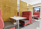 Thumbnail 32 of 40 - a seating area with chairs and tables in a room