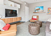 Thumbnail 29 of 40 - a living room with couches and chairs and a tv