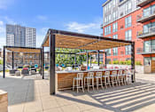 Thumbnail 23 of 40 - a rendering of a rooftop bar and patio with a city skyline in the background