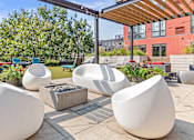 Thumbnail 22 of 40 - a rooftop patio with chairs and tables and a fire pit