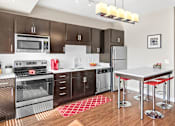 Thumbnail 12 of 40 - a modern kitchen with stainless steel appliances and a white counter top
