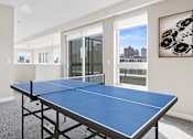 Thumbnail 11 of 40 - a games room with a ping pong table and a view of the city