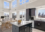 Thumbnail 4 of 40 - a kitchen with a large island and a living room with a table and chairs