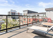 Thumbnail 26 of 40 - a balcony with a view of the city and a chair and a table