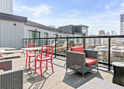 Thumbnail 33 of 40 - a balcony with a view of the city and chairs and tables