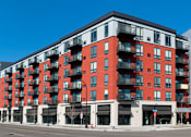 Thumbnail 36 of 40 - Exterior of Red 20 Apartments; a red and white building with black balconies.