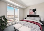 Thumbnail 6 of 40 - Spacious bedroom with a large window reaching the floor.