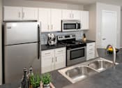 Thumbnail 2 of 28 - Sleek and modern kitchen with stainless steel finishes and a breakfast bar for casual dining.