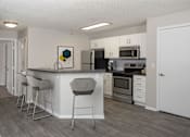 Thumbnail 1 of 28 - Modern kitchen with open layout, stainless steel appliances, and white cabinetry.