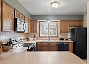 Thumbnail 2 of 17 - a kitchen with black appliances and wooden cabinets