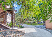 Thumbnail 13 of 17 - a walkway leading to a house with trees and a sidewalk