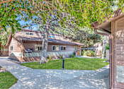 Thumbnail 9 of 17 - a house with a sidewalk and trees in front of it