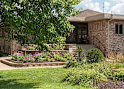 Thumbnail 18 of 23 - a brick building with a tree in front of it