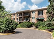 Thumbnail 19 of 23 - a picture of an apartment building with trees and bushes in front of it