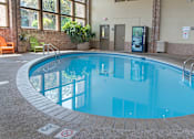 Thumbnail 17 of 23 - a swimming pool with blue water and brick flooring