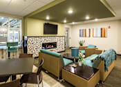 Thumbnail 6 of 18 - a lobby with couches chairs and tables and a fireplace