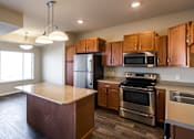 Thumbnail 1 of 18 - an empty kitchen with wooden cabinets and stainless steel appliances