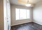 Thumbnail 3 of 18 - an empty living room with a large window and wood flooring