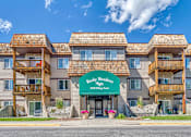 Thumbnail 17 of 20 - a large apartment building with a green sign in front of it