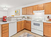 Thumbnail 1 of 14 - a kitchen with white appliances and wooden cabinets