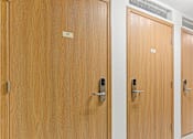 Thumbnail 10 of 14 - a row of four wooden doors in a hallway
