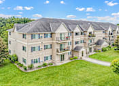 Thumbnail 9 of 14 - an aerial view of an apartment building with green grass and trees