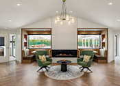 Thumbnail 27 of 34 - A modern living room with a fireplace and two green chairs.