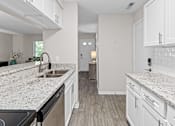 Thumbnail 3 of 34 - A kitchen with white cabinets and granite countertops.