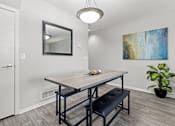 Thumbnail 6 of 34 - A dining room with a wooden table and bench.
