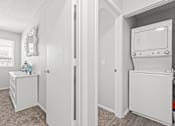 Thumbnail 12 of 34 - A white refrigerator is in a kitchen with a white wall and a white door.