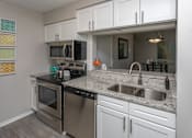 Thumbnail 4 of 29 - Kitchen Nook with Appliances, White Cabinets and Granite Counter Tops