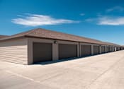 Thumbnail 10 of 12 - a row of garages with a blue sky in the background