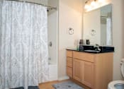 Thumbnail 8 of 12 - Private master bathroom with full shower and large mirror above sink.