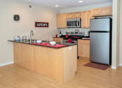Thumbnail 2 of 12 - Kitchen with light wood cabinetry, large breakfast bar, and stainless steel finishes.
