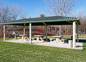 Thumbnail 31 of 34 - Covered community picnic area with tables and grills for outdoor dining.