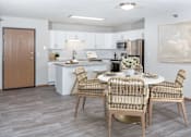 Thumbnail 1 of 34 - a dining area with a table and chairs and a kitchen in the background
