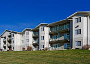 Thumbnail 33 of 34 - A large apartment complex with multiple balconies and green railings.