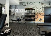 Thumbnail 17 of 34 - A gym room with a wall mural that says "The stronger you are, the better you feel.".