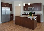 Thumbnail 2 of 15 - Kitchen with Dark Wood Cabinets, Island and Appliances