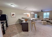 Thumbnail 3 of 9 - Full Kitchen with Breakfast Bar and Open Furnished Living Room with Windows