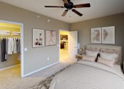 Thumbnail 5 of 9 - Spacious Bedroom with framed art on the walls and ceiling fan. Door in back corner opens to closet space.