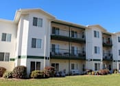 Thumbnail 12 of 12 - Exterior of The Meadows Apartments with multiple large windows and balconies.