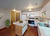 Thumbnail 2 of 12 - Side view of a spacious kitchen with white cabinetry and ample amounts of storage space.