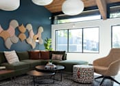 Thumbnail 22 of 28 - a living room with blue walls and a green couch at The Bosk Apartment Homes, Woodbury, MN, 55125